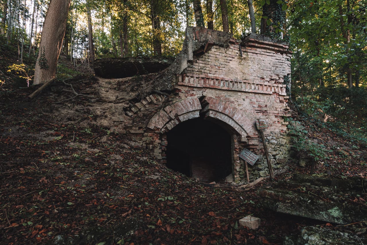 Eine überwucherte, halb eingestürzte Ruine mit moosbewachsenen und brüchigen Mauerstrukturen.