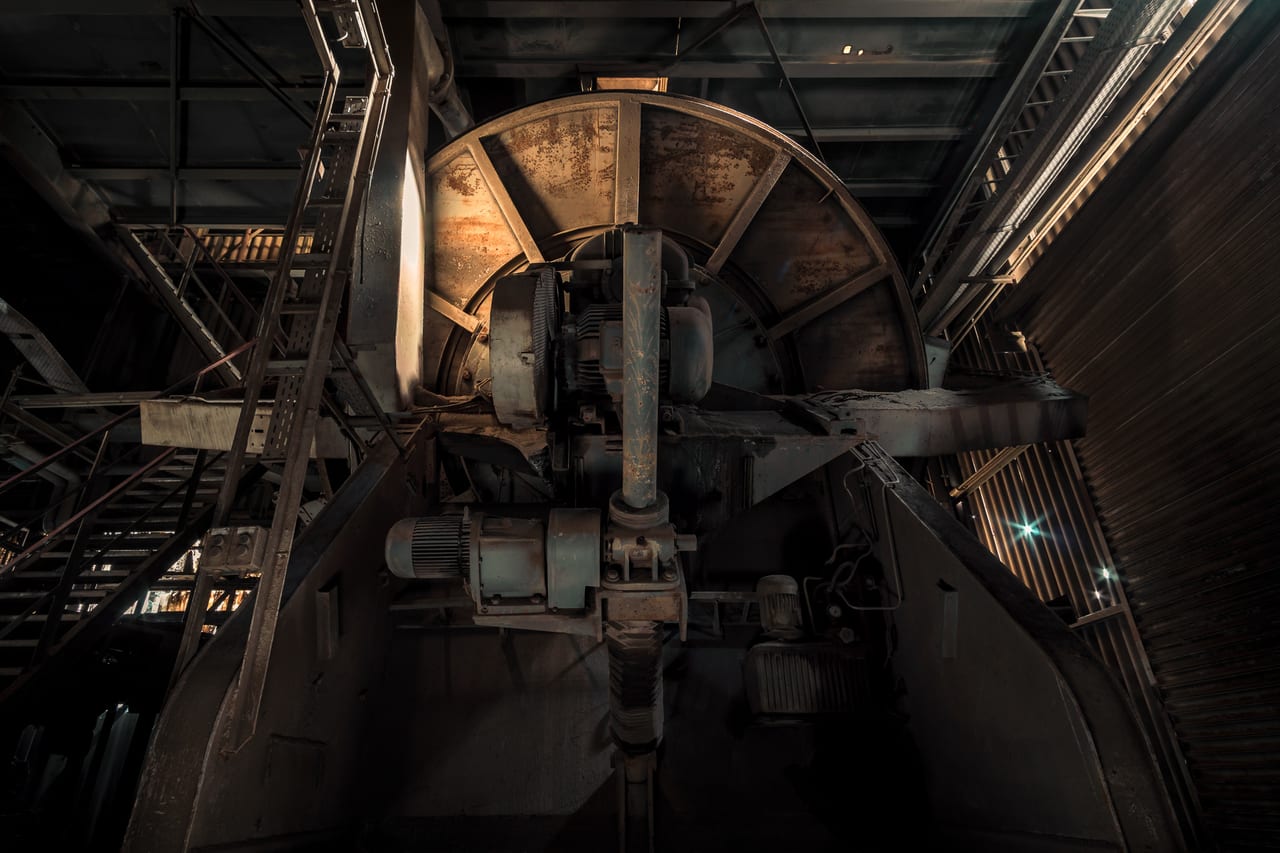 Eine Nahaufnahme der rostigen und verfallenen Unterseite einer alten Industriemaschine.