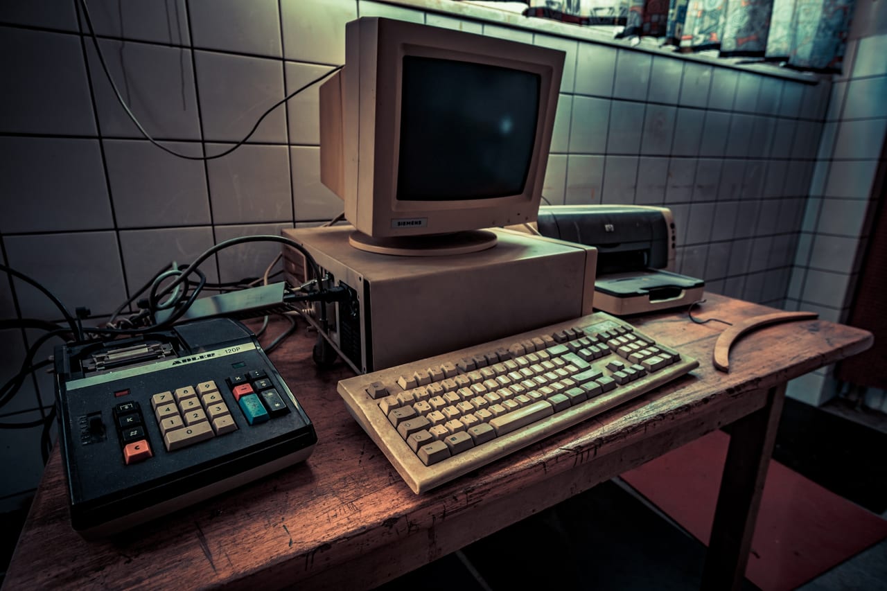 Ein verlassener Arbeitsplatz mit veralteter Computertechnik aus den 1990er-Jahren.